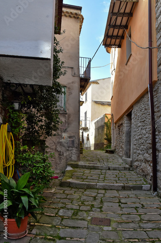 Fototapeta Naklejka Na Ścianę i Meble -  Civitanova del Sannio, 11/23/2019. A narrow street among the old houses of a mountain village in the Molise region