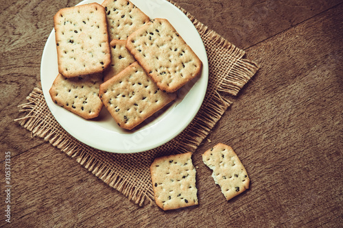 Closeup of black sesame crackers on white plate. Closeup of snacks plate.