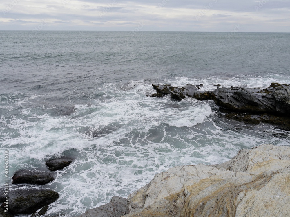 Fototapeta premium Top shot of waves breaking on the rocky shores