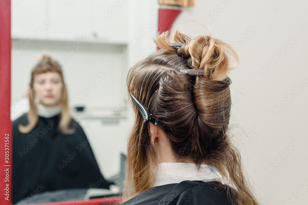 Fototapeta premium Closeup of professional stylist using brush to apply dye on clients hair