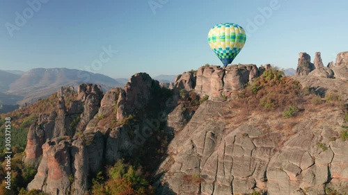 Amazing panoramic video with hot air balloon flying over picturesque rock formation lit by the morning autumn sun, Belogradchik rocks, Bulgaria 