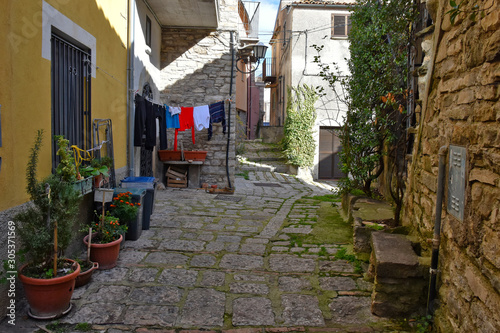 Fototapeta Naklejka Na Ścianę i Meble -  Civitanova del Sannio, 11/23/2019. A narrow street among the old houses of a mountain village in the Molise region