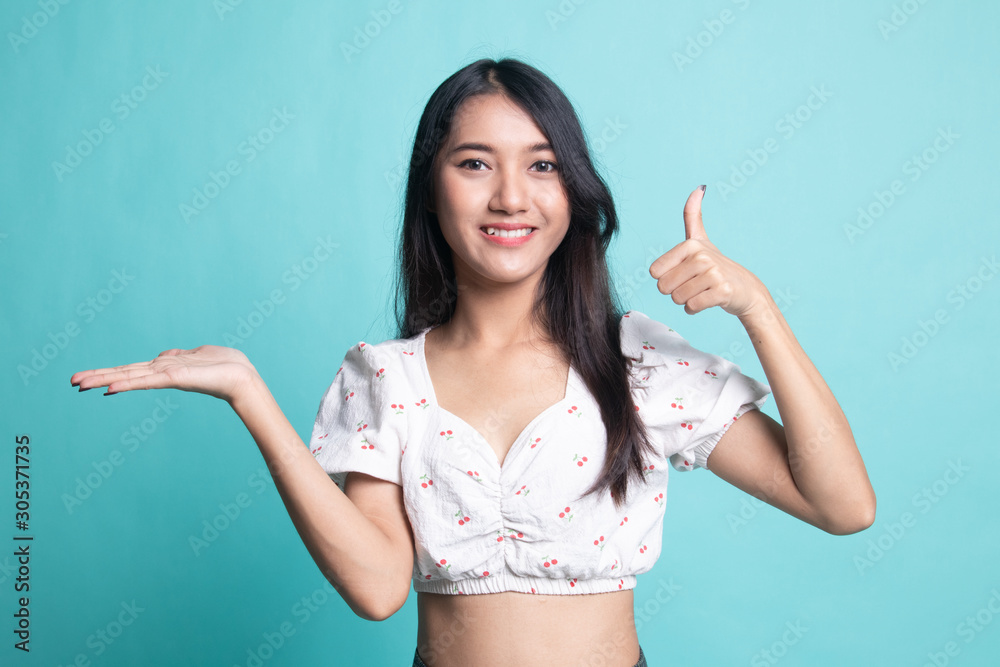 Beautiful young Asian woman show palm hand and thumbs up Beautiful young Asian woman show palm hand and thumbs up