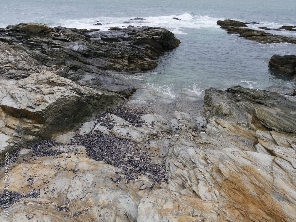 Water flows into a small cove formed by rocks