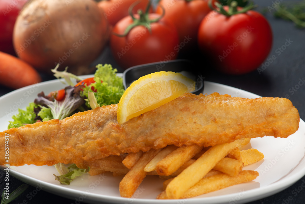 fish and chips with french fries in dark background fish and chips with french fries in dark background