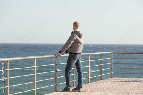 A young man standing on the sea shore