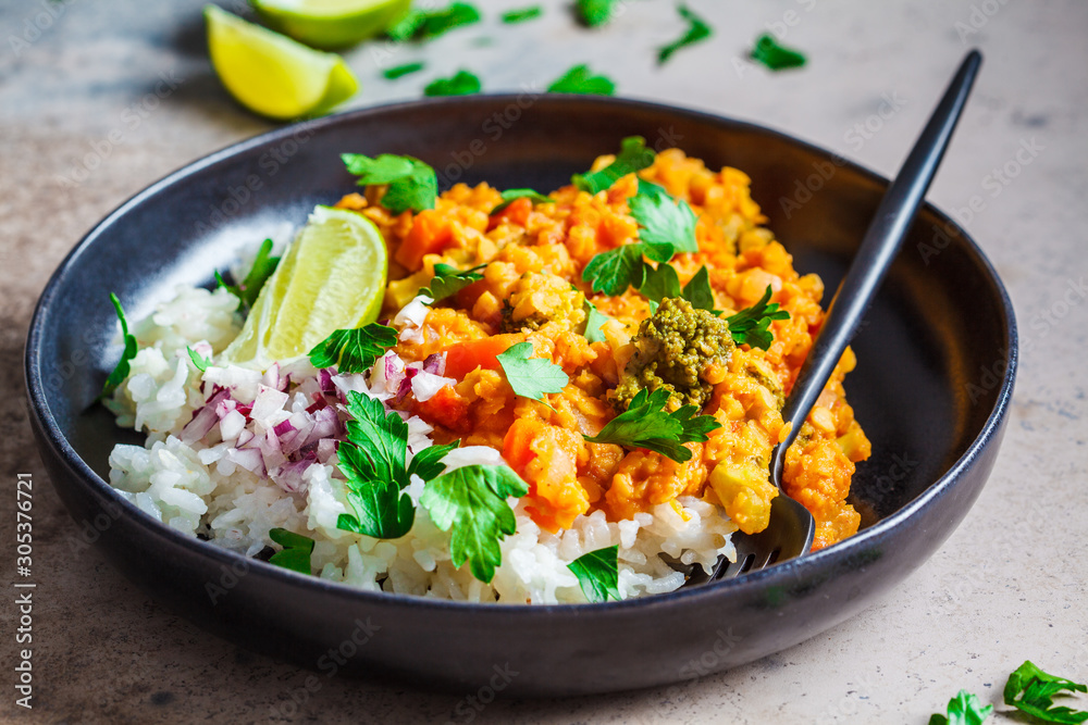 Vegetarian lentil curry with rice in black plate. Healthy vegan food concept. Vegetarian lentil curry with rice in black plate. Healthy vegan food concept.