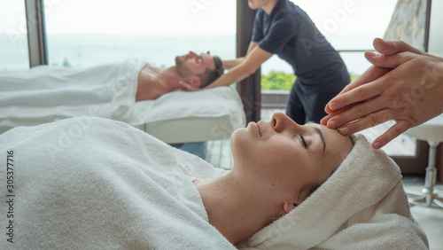 Close up of an young couple is receiving a facial massage and spa treatment for perfect skin in a luxury wellness center.