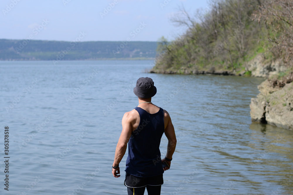 Young man looks at a beautiful view of the lake