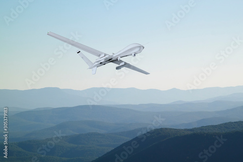 Spy unmanned aerial vehicle  UAV  flies over low mountains in mist