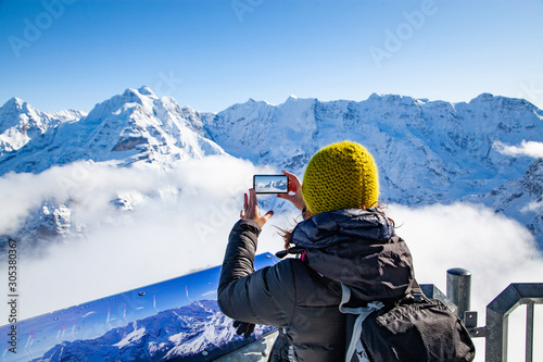 woman traveler in Swiss alps Jungfrau region taking pictures photo