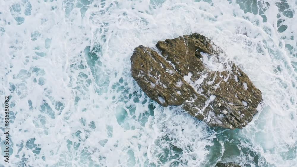 Aerial view of sea waves crashing on rock. Aerial view of sea waves crashing on rock.