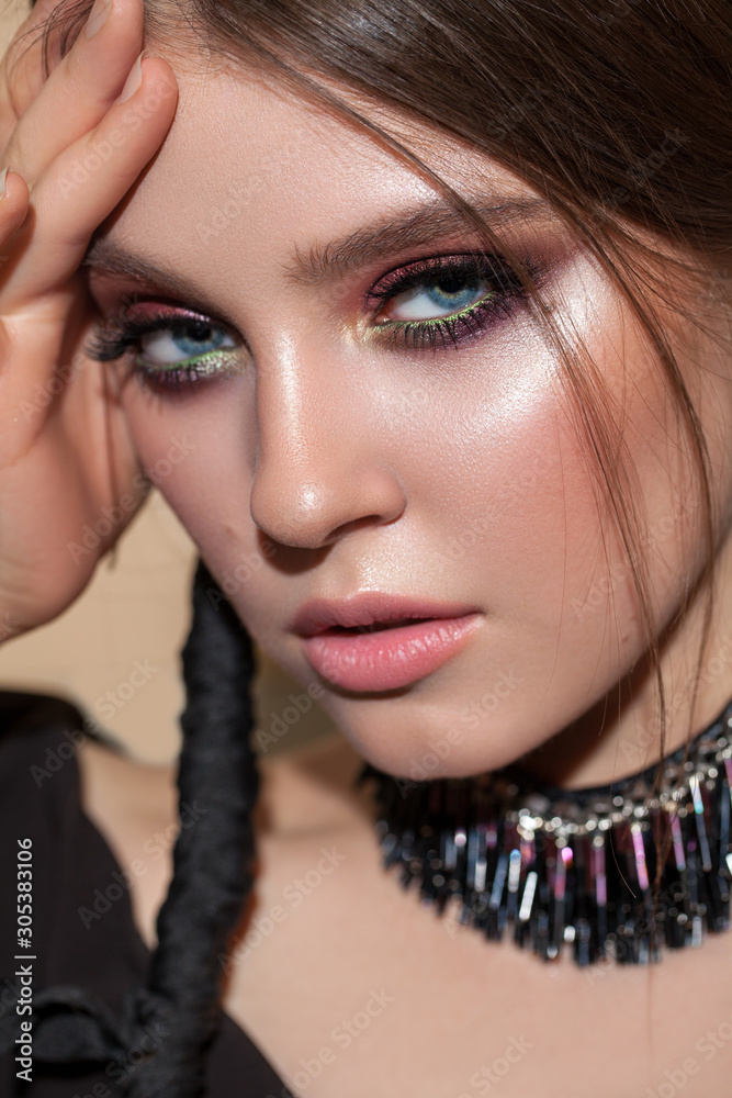 Young attractive model with the professional colorfull make-up, bright color eyeshadows and original braid hairstyle.