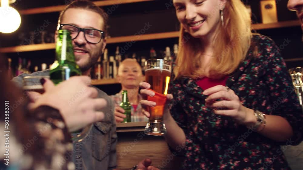 Friends standing in bar and toasting with beer. Friends standing in bar and toasting with beer.