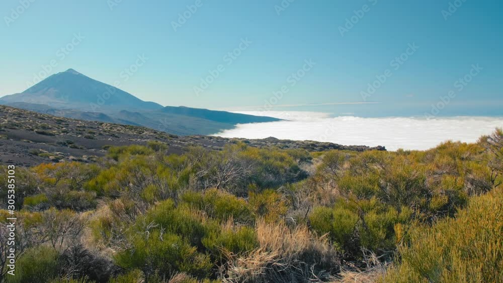 Above clouds after hard hike to the top of Teide volcano at Canary Islands. Hard one day hike to the top of volcano peak, view from above, bottom is hidden in clouds. Above clouds after hard hike to the top of Teide volcano at Canary Islands. Hard one day hike to the top of volcano peak, view from above, bottom is hidden in clouds.