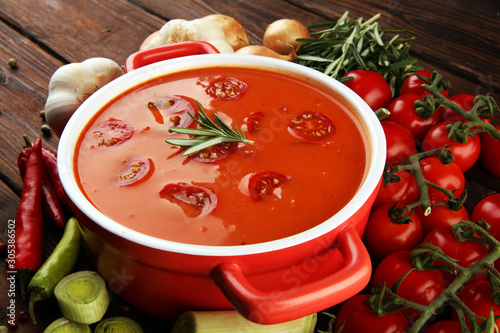 Tomato and fresh rosemary soup with garlic, cracked papper corns, served with cream. Homade tomato soup for dinner