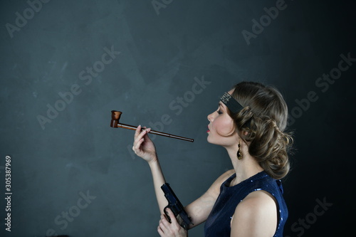 girl in evening blue dress with a pipe