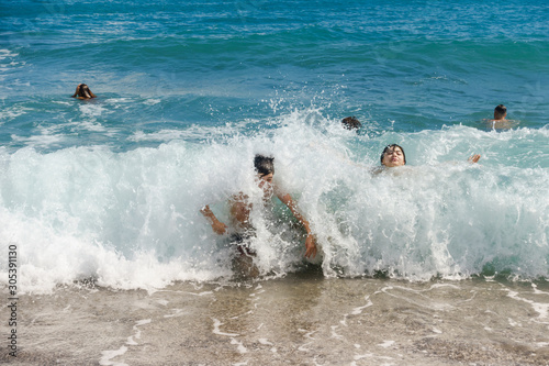 Children enjoying the wave splashes at the beach © samards