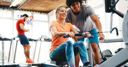 Young beautiful woman doing exercises with personal trainer photo