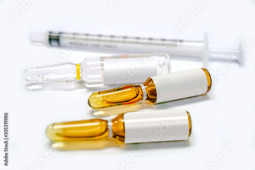 3 ml. brown Ampules of drug and plastic syringe on white background.