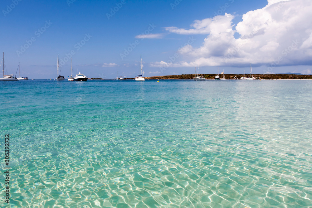 Turquoise water with boats in the background. Formentera Island, Spain
