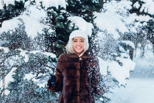 Happy young afro woman playing with snow in winter park
