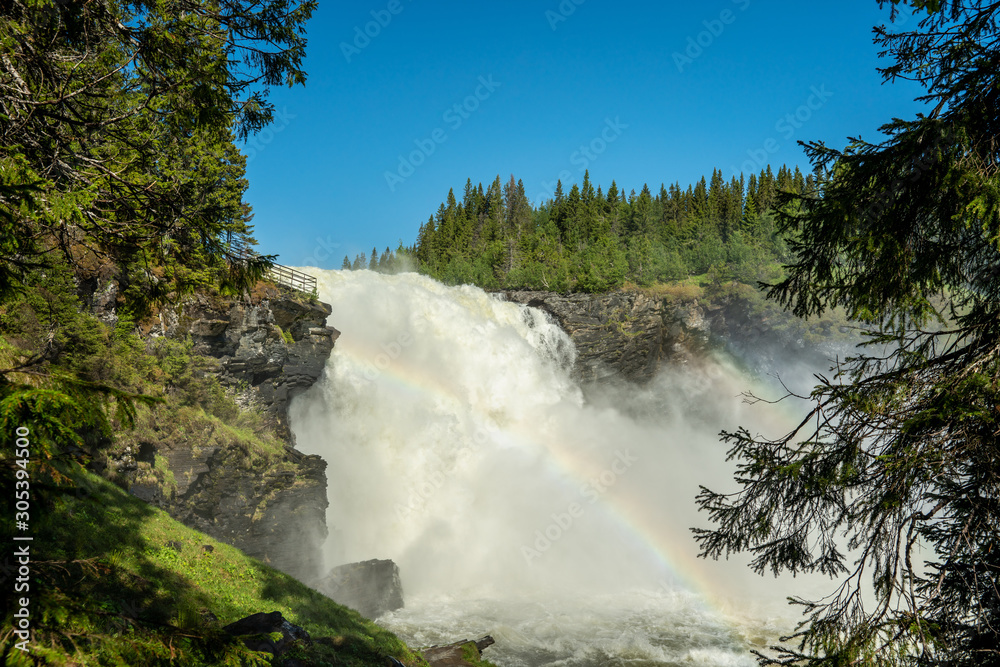 The waterfall Tannforsen in northern Sweden with a rainbows in the water spray