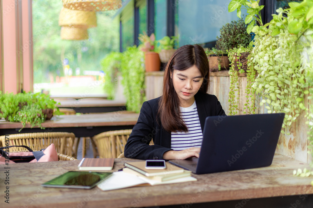 Young attractive business woman working on her computer at outdoor patio of her office Young attractive business woman working on her computer at outdoor patio of her office