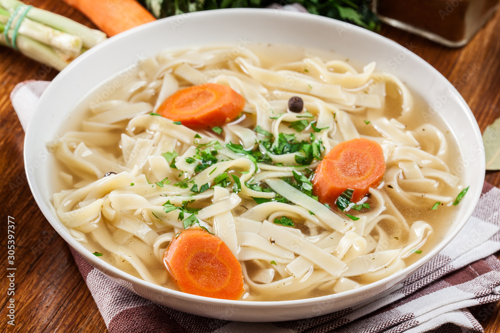 Tasty meat broth with noodles, carror and parsley Tasty meat broth with noodles, carror and parsley