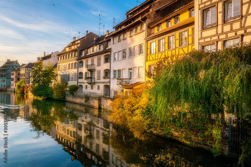 Scenic and iconic cityscape of historic Petite France disctrict, downtown Strasbourg, on a sunny late afternoon. Houses along the Ill river.