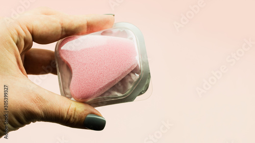 Close up of woman hand holding menstrual sponge tampon in packag