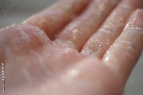 Wet hand with soap foam, macro photo.