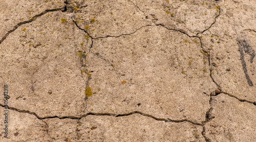 Cracked concrete texture closeup. Abstract cement background. Old concrete cement with cracks and natural destruction from time and weather conditions.