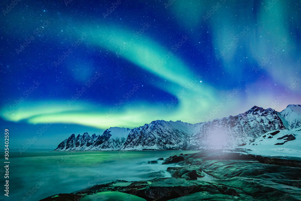 Vivid Northern lights during polar night on Lofoten Islands in Norway. Epic  scene of dancing aurora