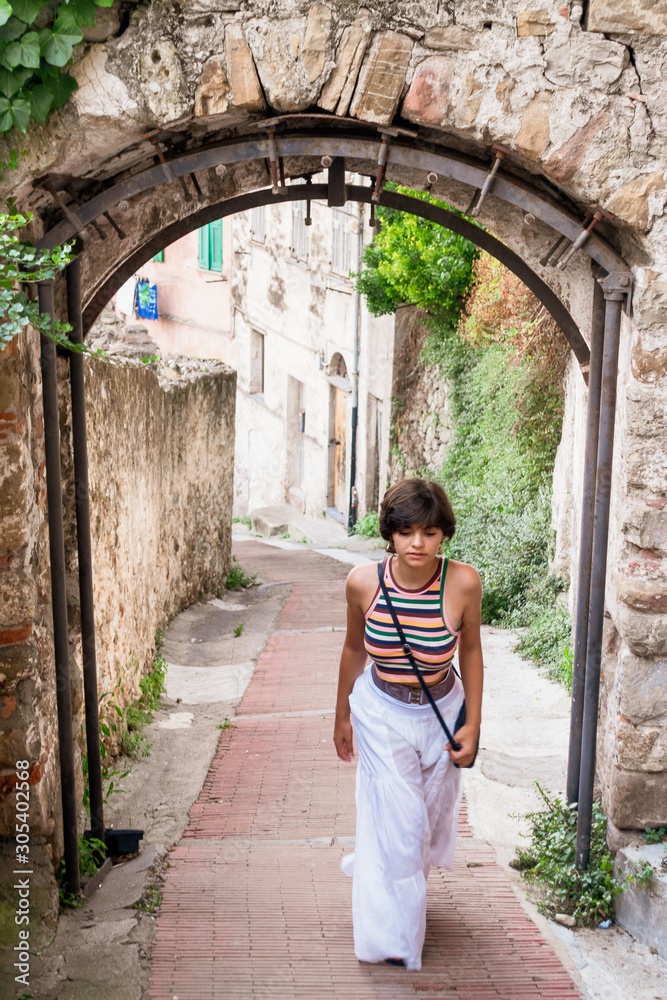 Girl walking uphill street in Ventimiglia