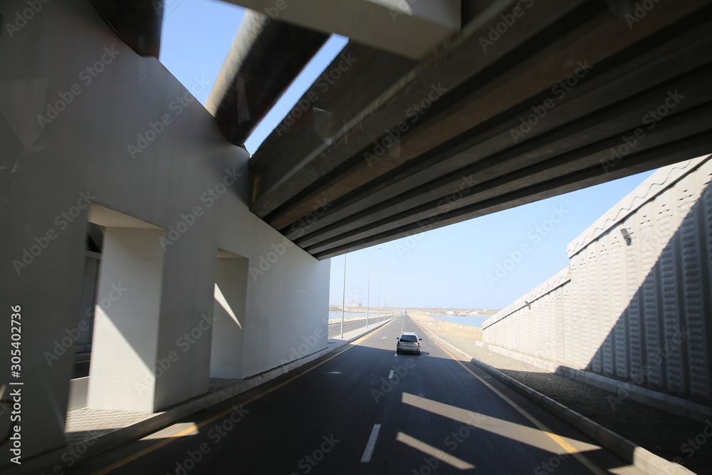 Fototapeta premium Concrete narrow underground tunnel for cars. Under the bridge is a pedestrian crossing.A small tunnel under the bridge on the road . road tunnel under bridge at day .