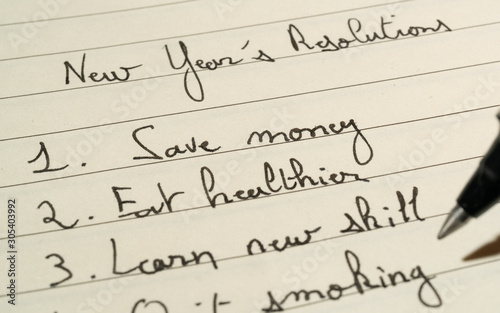 New Year s Resolutions list concept with a complete list on a notebook with a pen close up shot