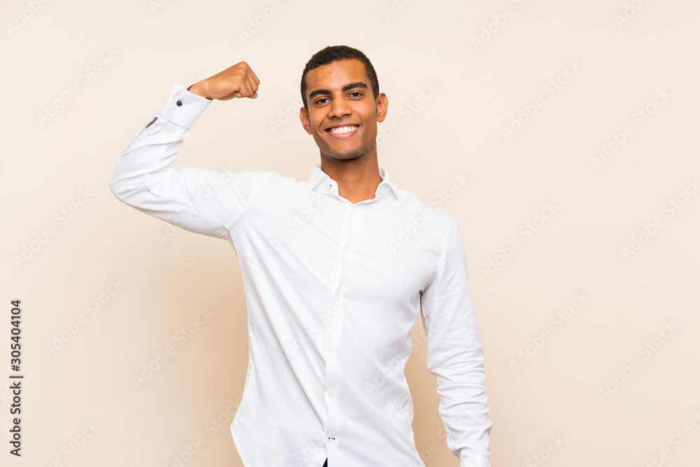 Young handsome brunette man over isolated background doing strong gesture Young handsome brunette man over isolated background doing strong gesture
