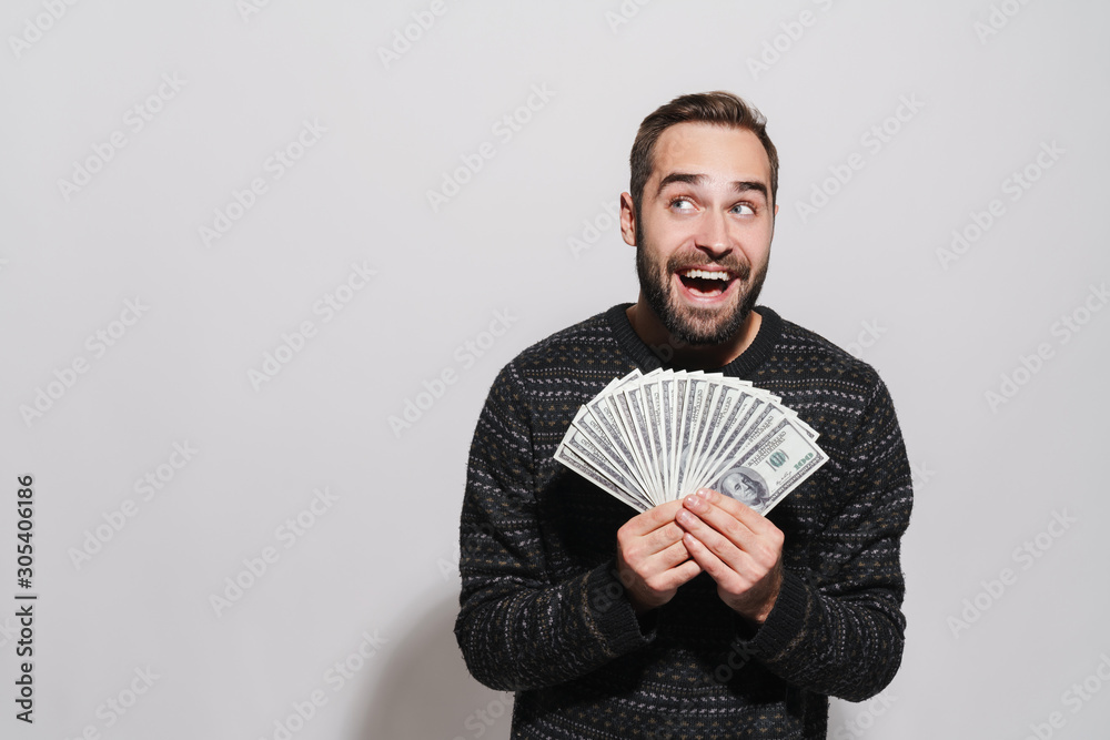 Image of happy brunette man screaming and holding dollar banknotes Image of happy brunette man screaming and holding dollar banknotes