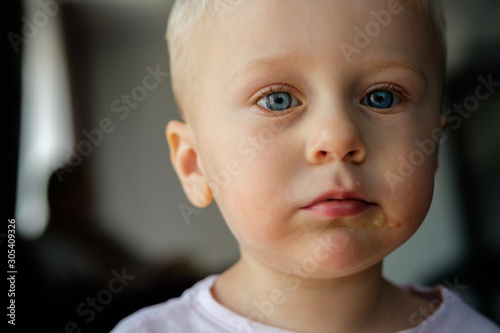 Portrait of a little blond boy with blue eyes