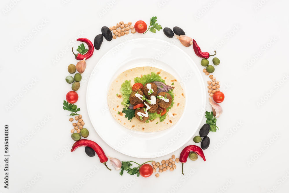 top view of vegetables arranged in round frame around falafel on pita on plate on white background top view of vegetables arranged in round frame around falafel on pita on plate on white background