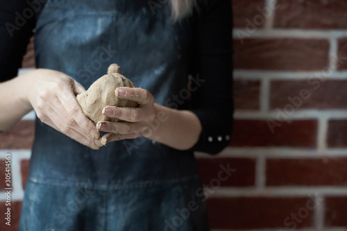 Unrecognisable woman making ceramic bowl in hand. Creative hobby concept. Earn extra money, side hustle, turning hobbies into cash, passion into job, copy empty space photo