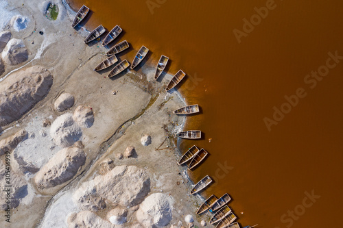 Aerial view of the small boats for salt collecting at pink Lake Retba or Lac Rose in Senegal. Photo made by drone from above. Africa Natural Landscape. photo