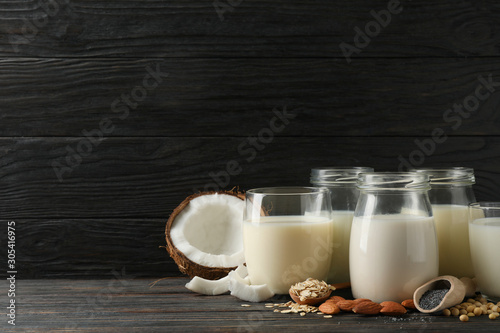 Glasses with diferent types milk on wooden background, space for text