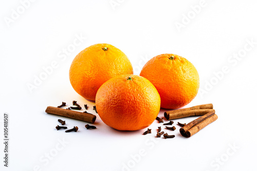 Fresh delicious juicy orange on isolated white background with cinnamon sticks and cloves