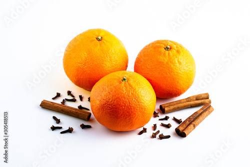 Fresh delicious juicy orange on isolated white background with cinnamon sticks and cloves