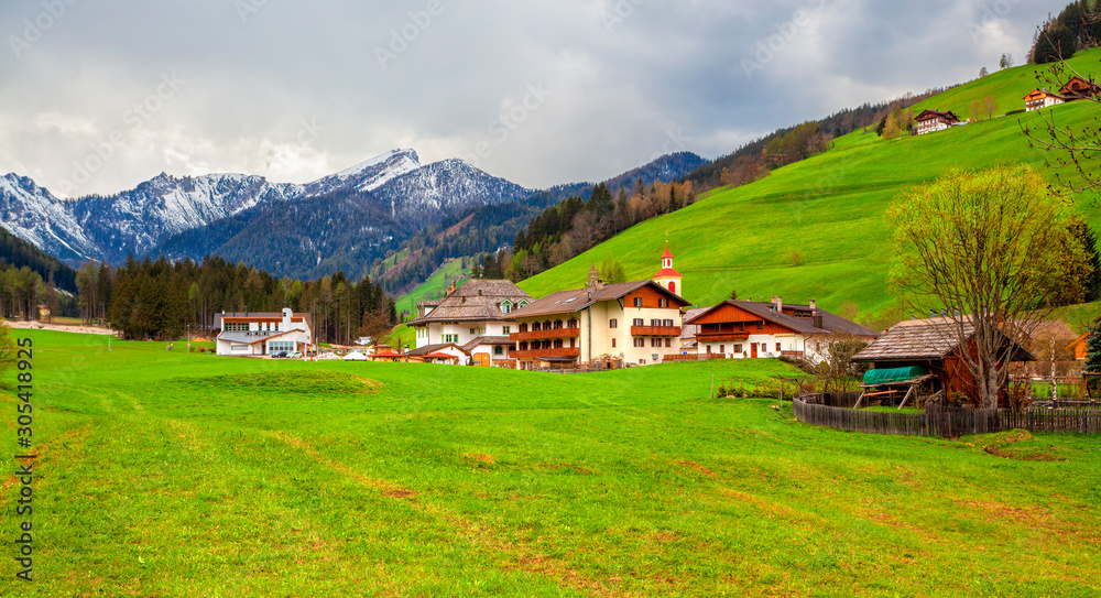  Landscape in the Alps with mountain chalets and green meadows, Dolomite Alps, Italy.