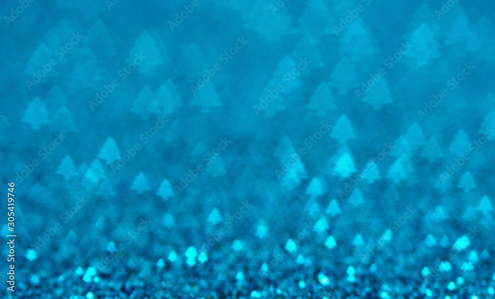 Blue holiday glitter background with Christmas tree bokeh.
