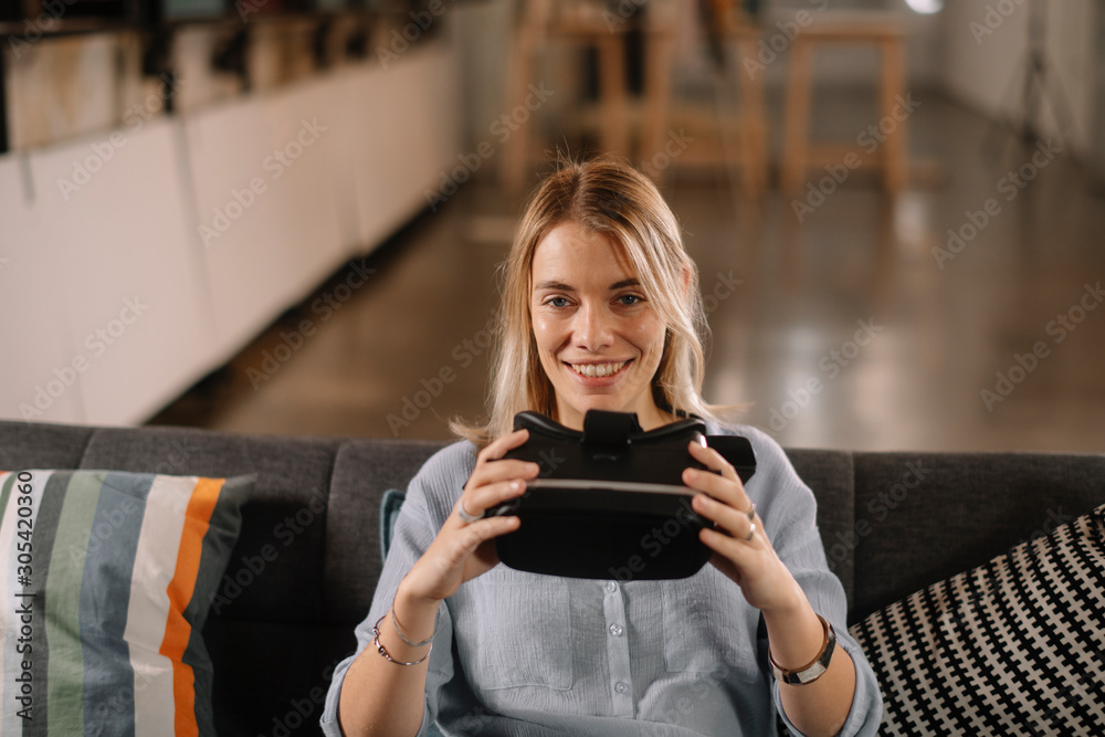 Young woman using vr. Beautiful woman using virtual reality on sofa. . Young woman using vr. Beautiful woman using virtual reality on sofa. .