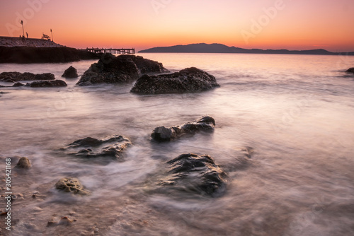 Beautiful seascape wave move on the rock at sunset